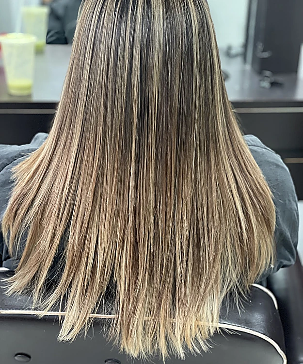 Balayage castaño a rubio en cabello largo y lacio, visto de espaldas