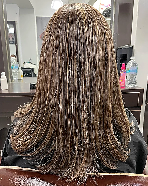 Cabello chocolate con luces caramelo y capas largas, visto de espaldas