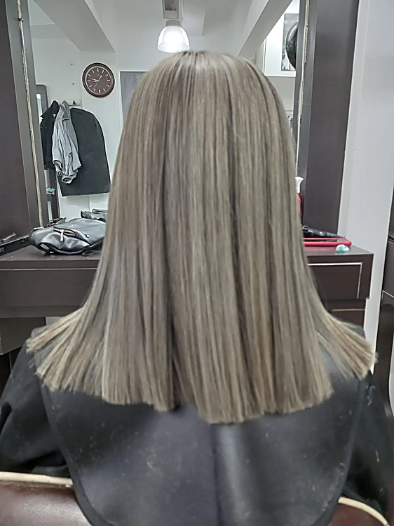 Corte recto a la altura de los hombros en tono ceniza, visto de espaldas