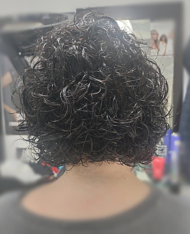 Rizos negros pequeños y definidos en cabello corto